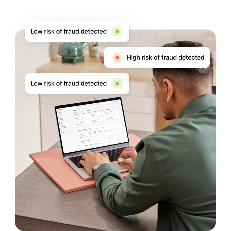PlatformDTC merchant sitting at a desk with a laptop and receiving notifications of low-risk and high-risk fraud.
