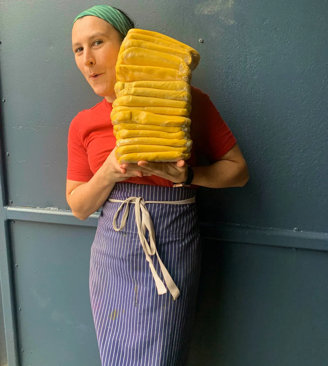 Laurie Ellen carrying a stack of pastery dough while making a funny face.