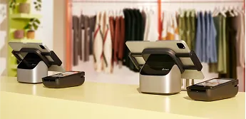 A PlatformDTC tablet stand on a sales counter with a payment terminal next to it.