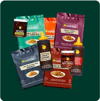 Multiple packets are various kinds of at-home Momofuku ramen noodles.