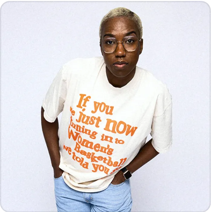 A woman in a white t-shirt with orange writing.