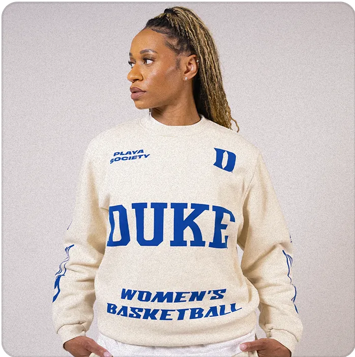 A woman looking away from the camera wearing a long-sleeved Duke t-shirt.